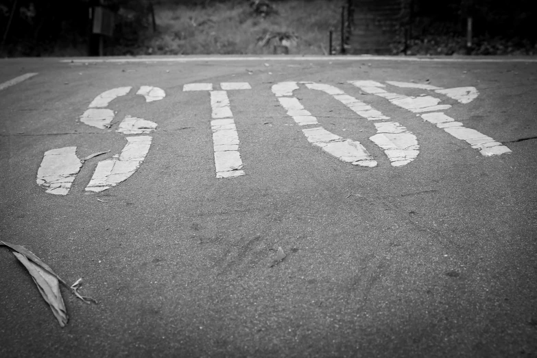 a stop sign painted on the street in black and white