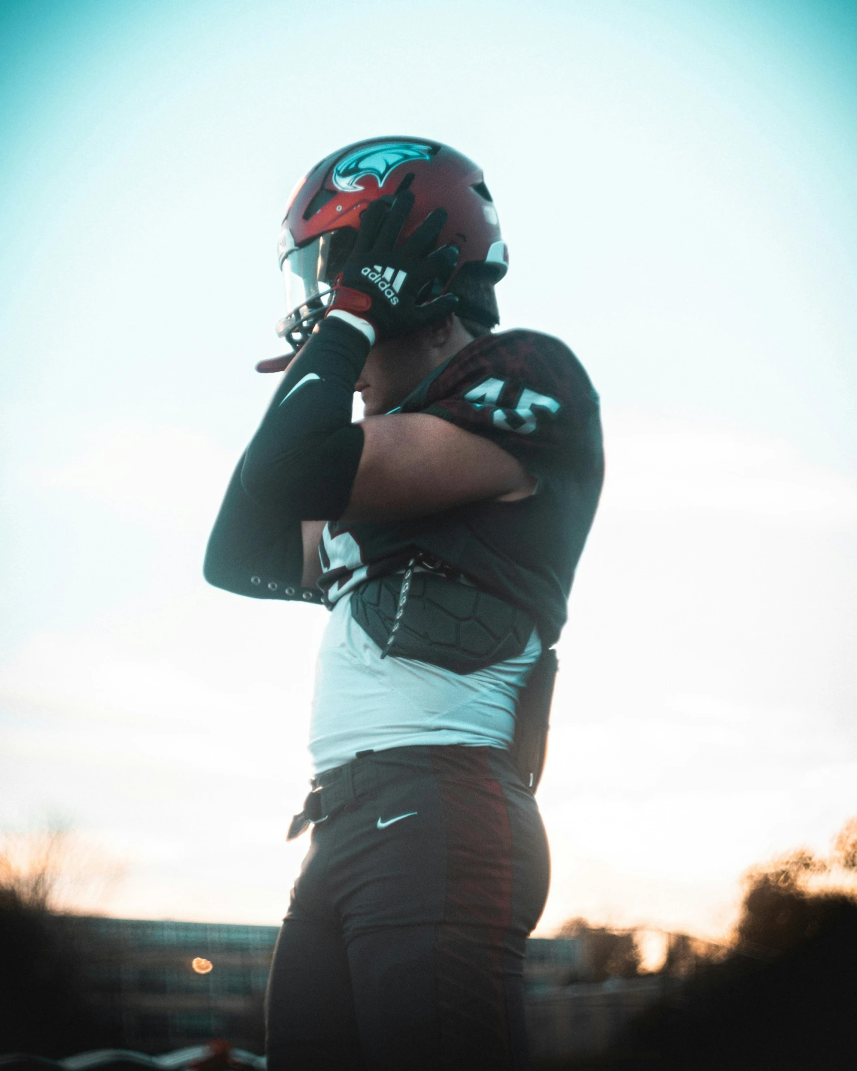 a football player holding a baseball bat with a helmet