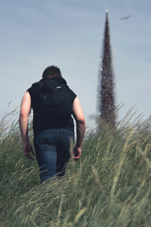 a person in a black vest and a tall, slender grass