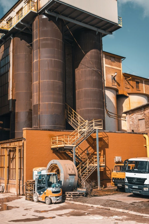 an industrial building with some very large tanks outside