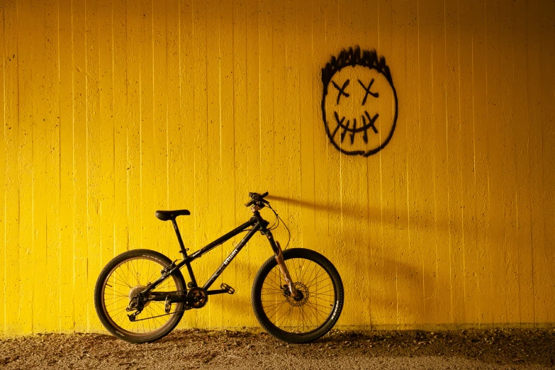 a bike on a wall near graffiti spray painted on it