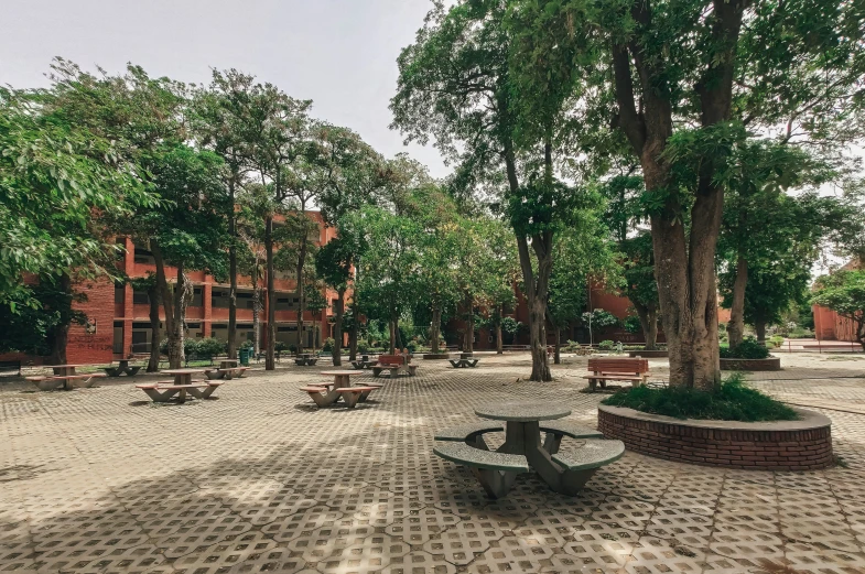 a park with trees, benches and chairs in the middle