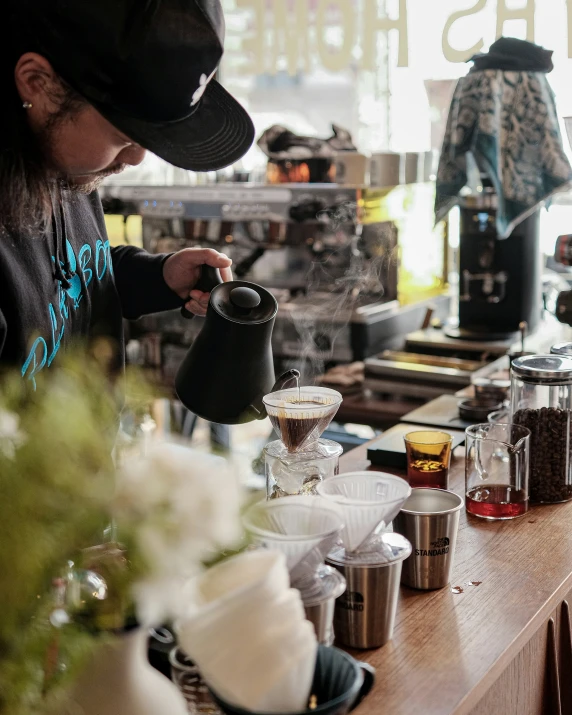 a person pouring coffee into a cup in front of a counter