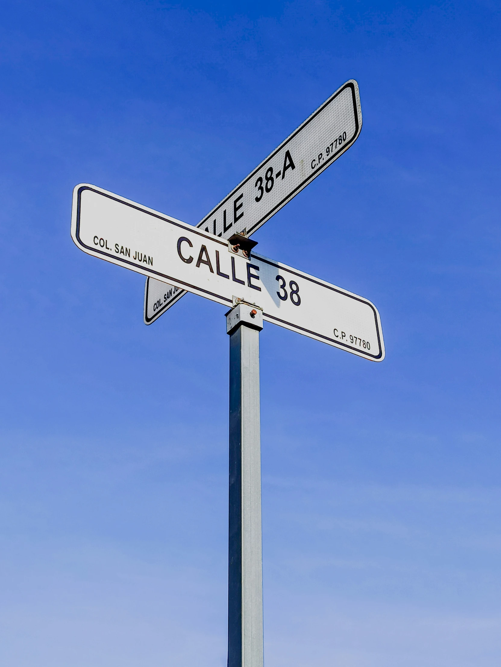 two street signs are standing in the grass