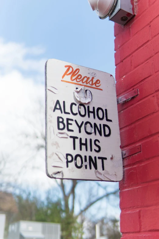 a sign on a brick wall next to a fire hydrant