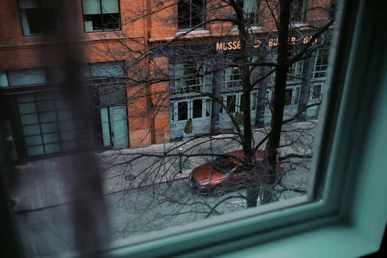 a red car is sitting outside the window