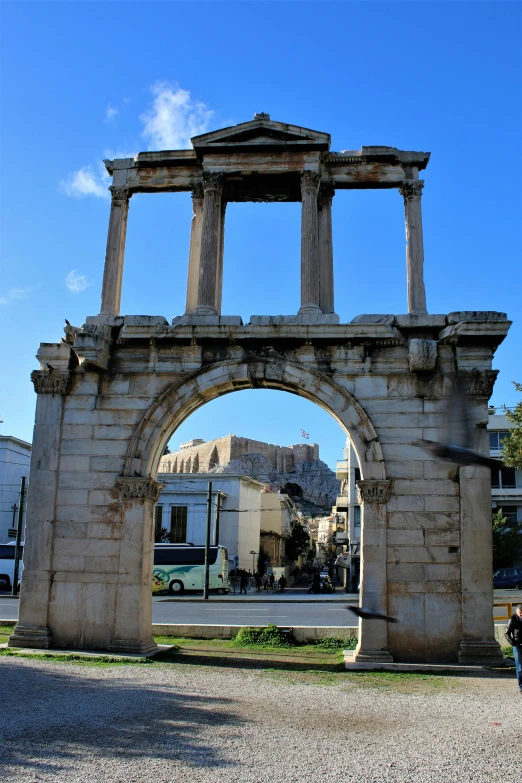 an arch with statues around it that looks to be built on the side of a street