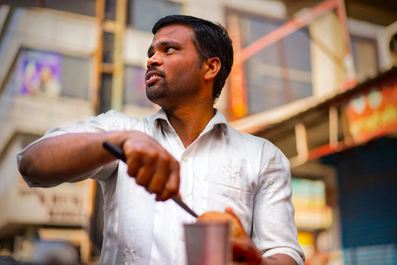 a man standing with his hand on a piece of fruit and a knife