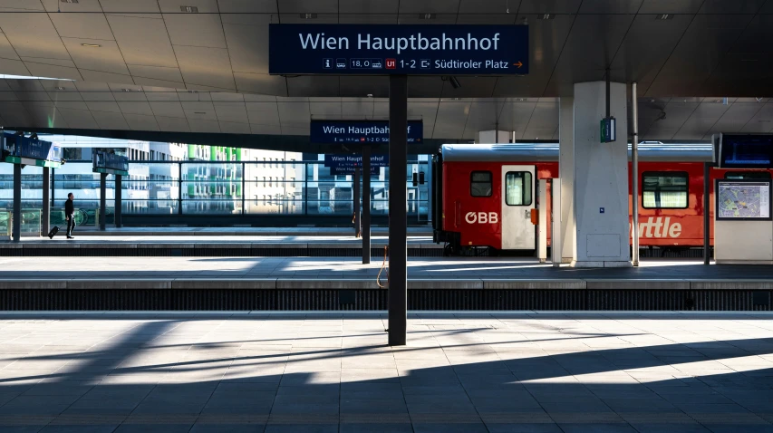 a train station with a red train at it