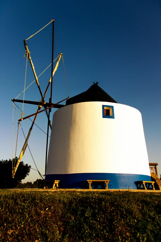 a white water tower sits in the middle of a field