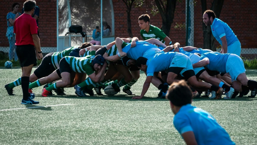 a team of rugby players huddle together on the field