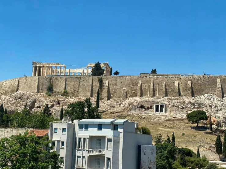 a large building on top of a hill with some trees around