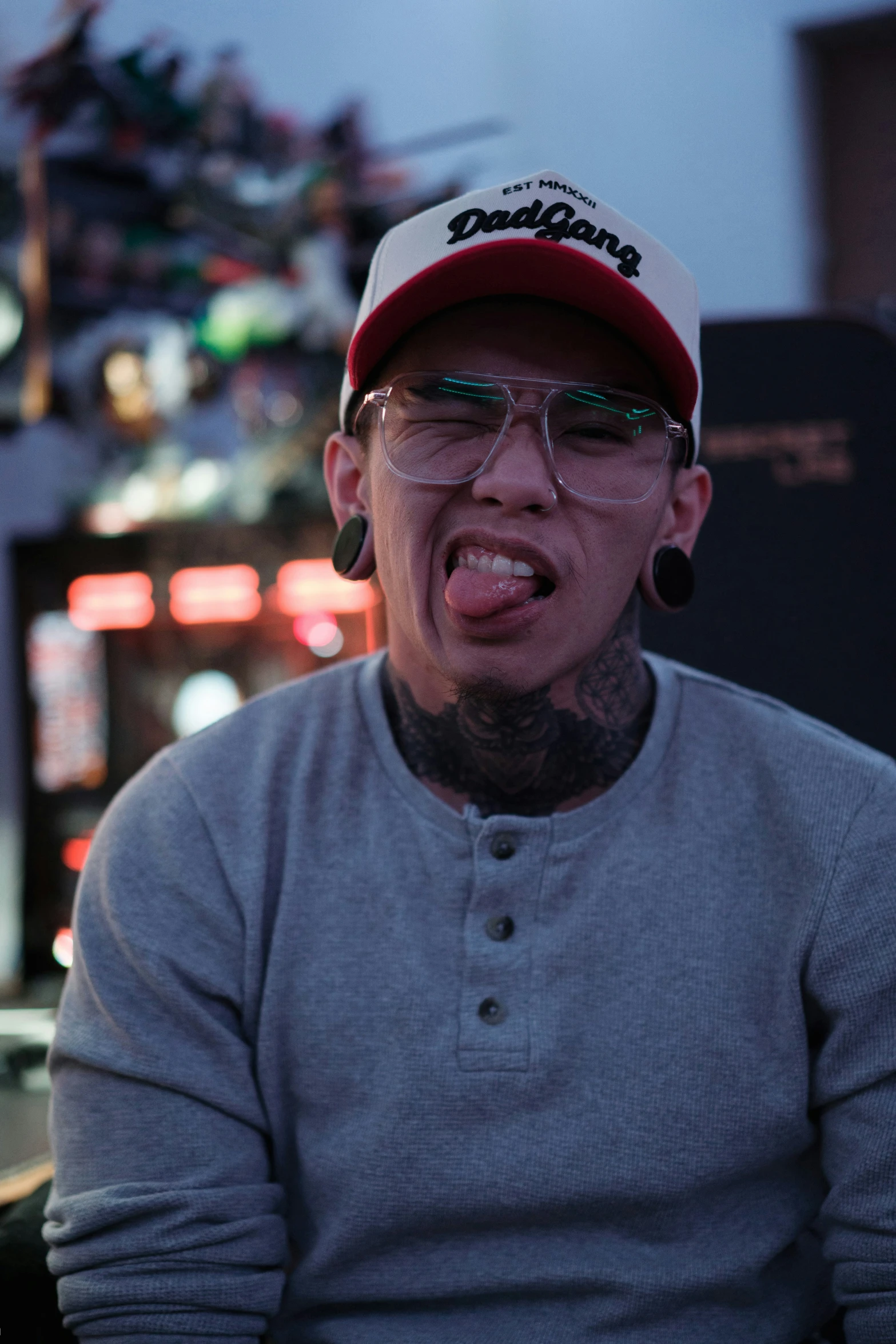 a man in a red hat making his face while sitting in front of a bar