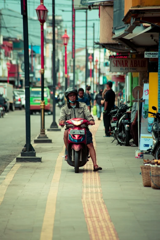 a man riding a scooter down the middle of a street