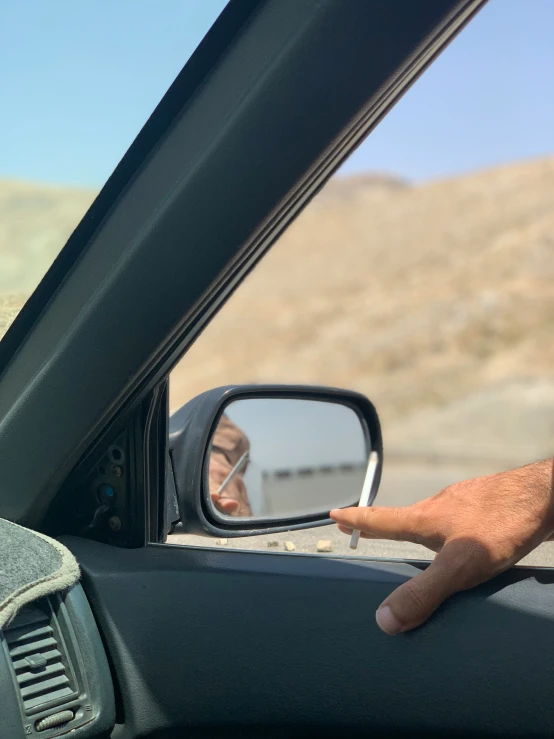 the driver shows off his small hand held mirror