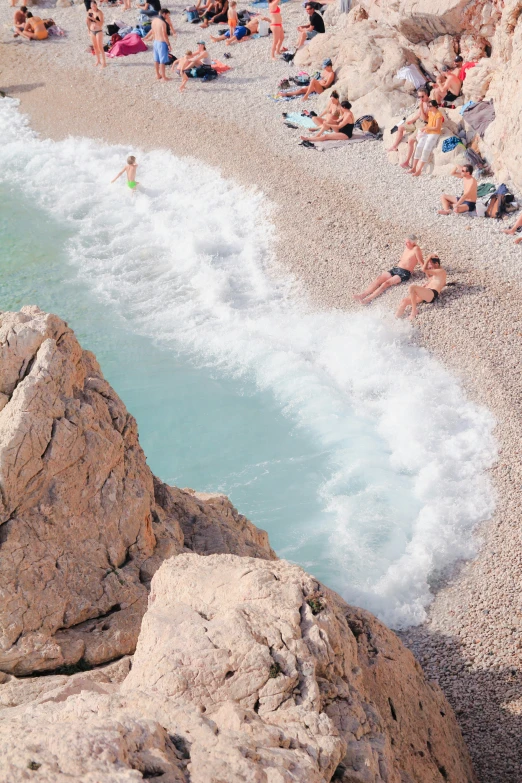 people lay on the beach as they play in the water