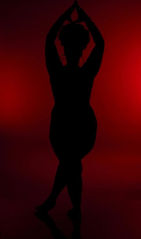 the silhouette of a woman making a heart sign in front of a red background