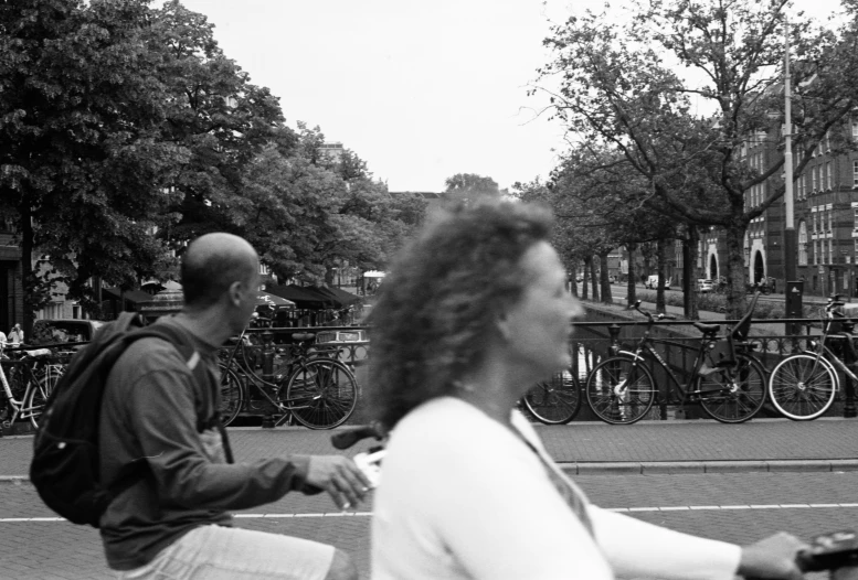 two people walking on the road near many bikes