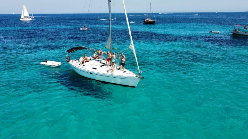 a group of people are on the sailboat in the water