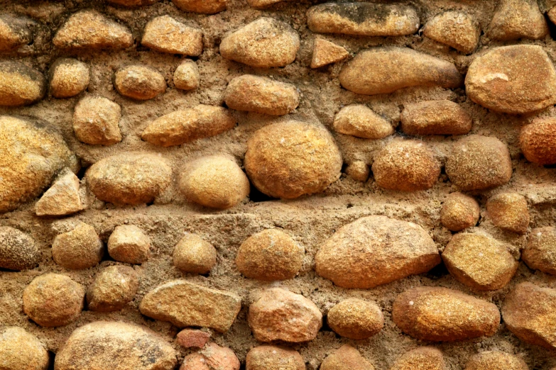 many different rocks together against a stone wall