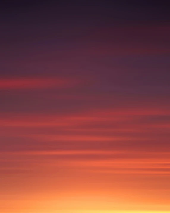 a plane in the sky at sunset with clouds