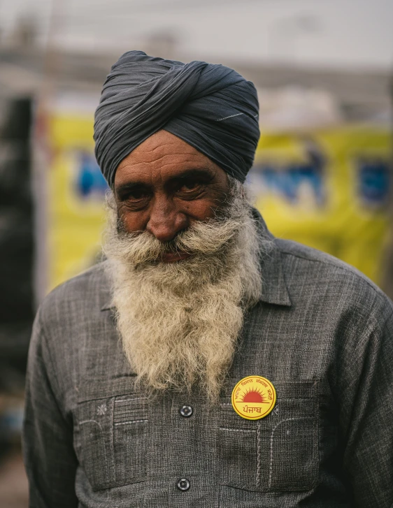 an old man with a beard and a yellow badge