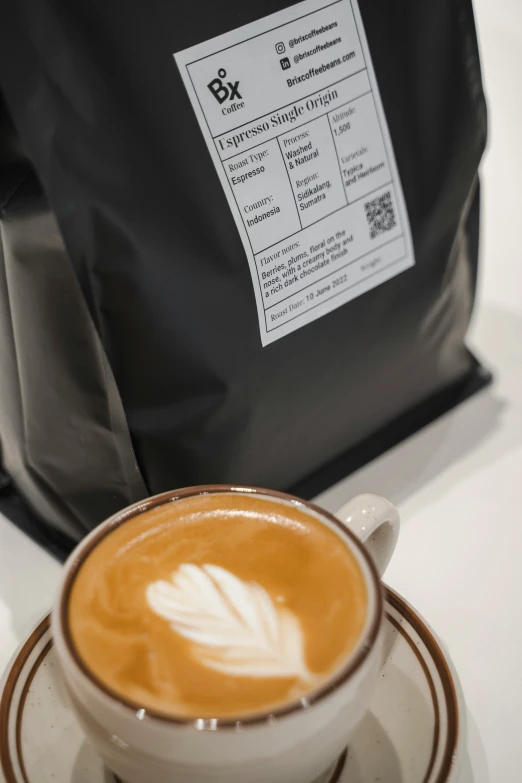 an cappuccino and bag of coffee sitting on top of a counter