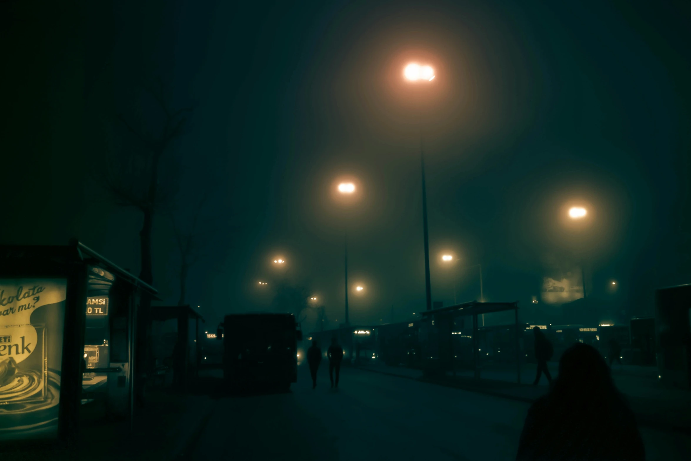 people walking on the sidewalk under street lights