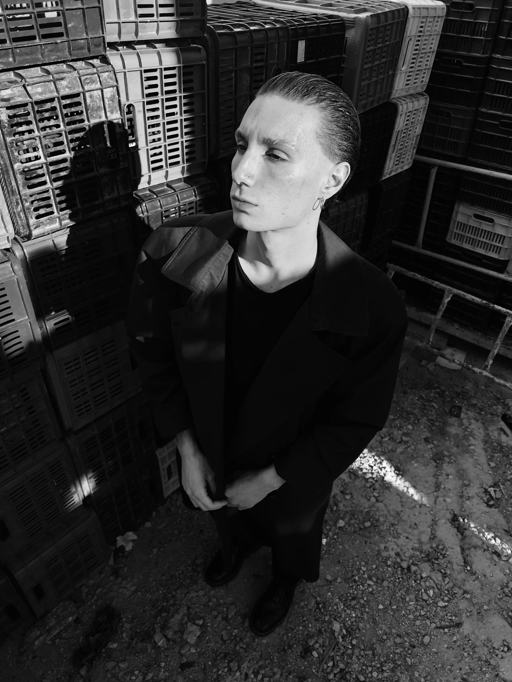 black and white pograph of a woman standing in front of stacks of crates