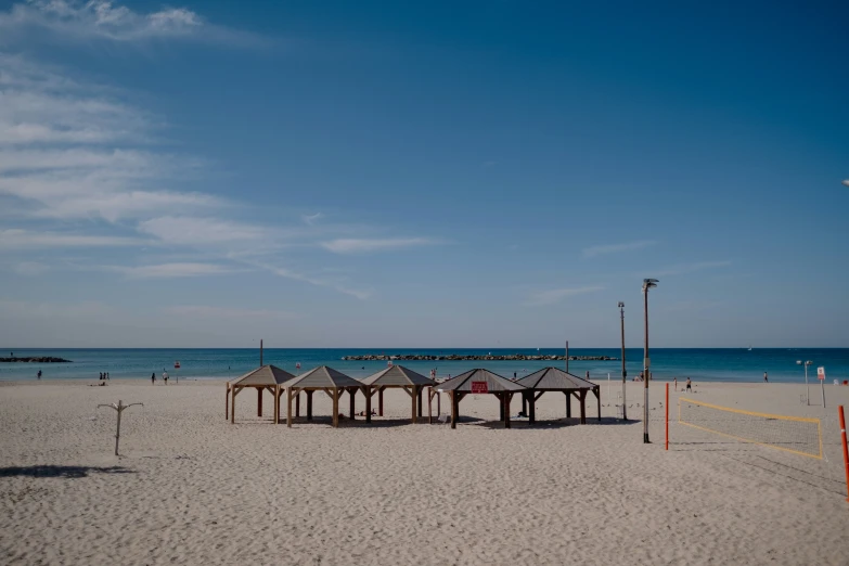 a beach with some volleyball and an umbrella