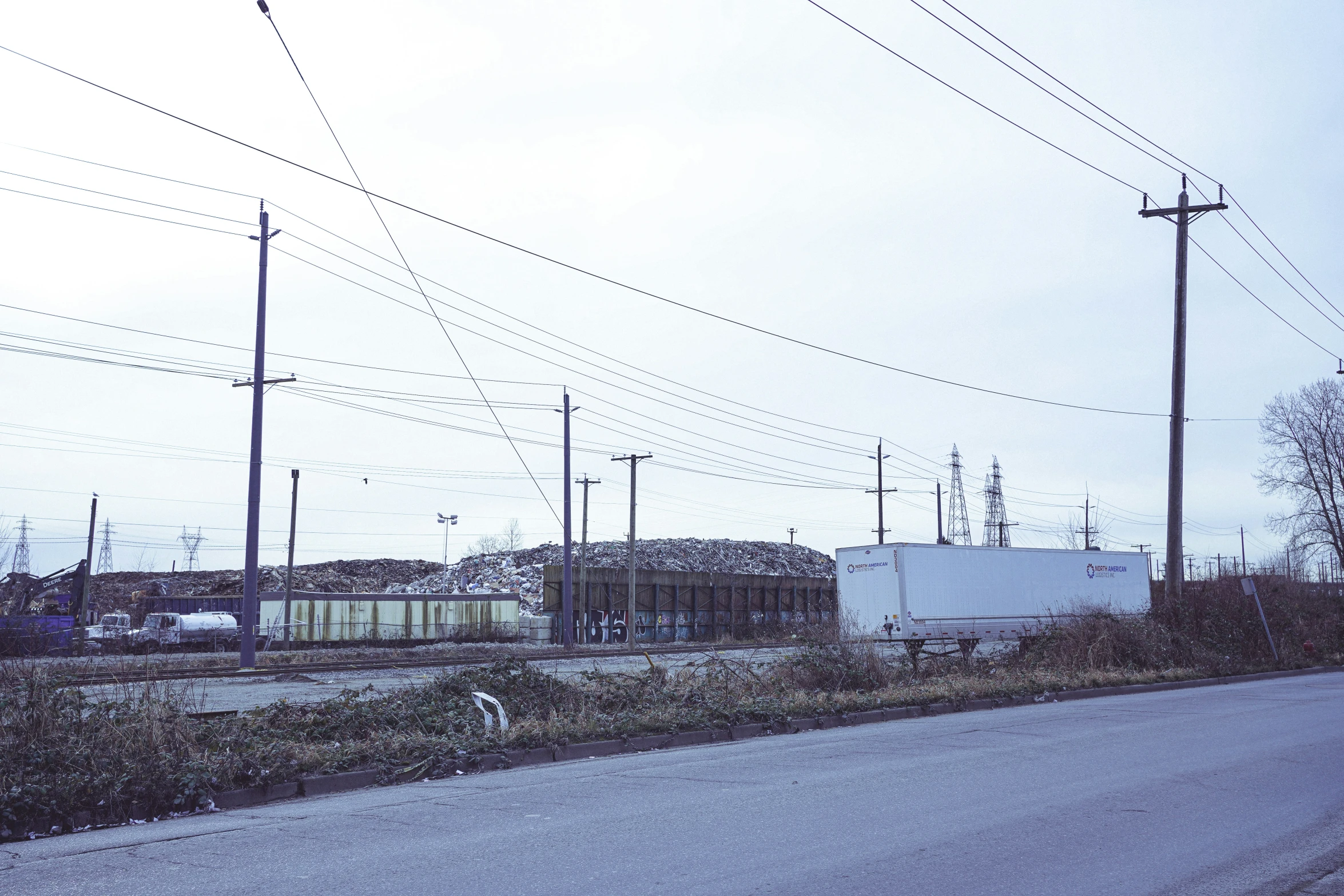 a train on a track behind many power lines