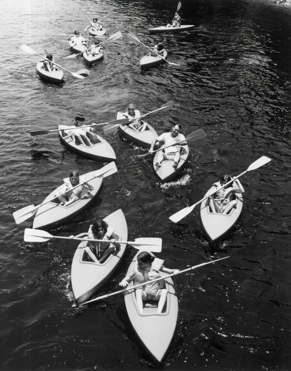 several men on four boats with oars and one canoe