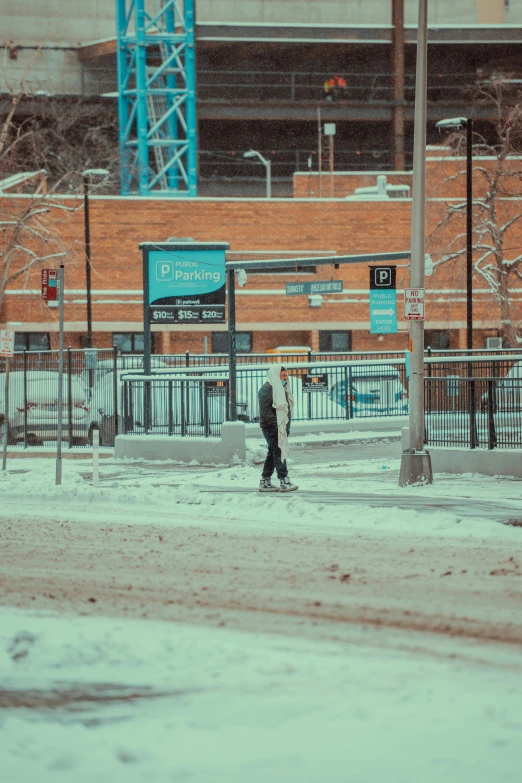 a man walking across the road on a snowy day