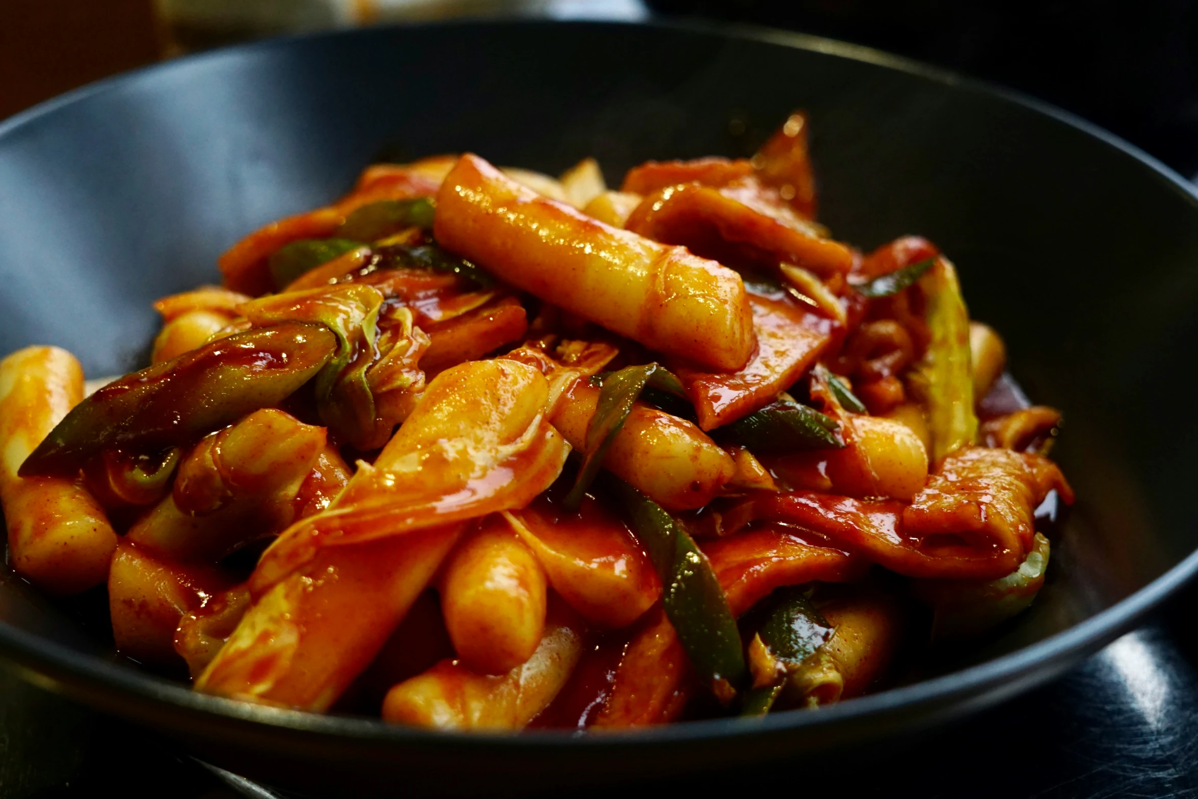 a metal bowl filled with pasta and vegetables