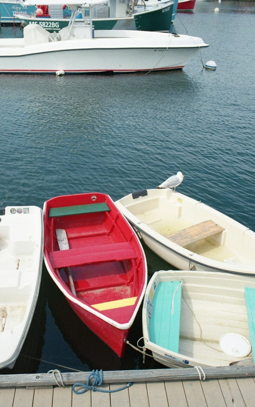 three boats docked in a harbor with a boat in the background