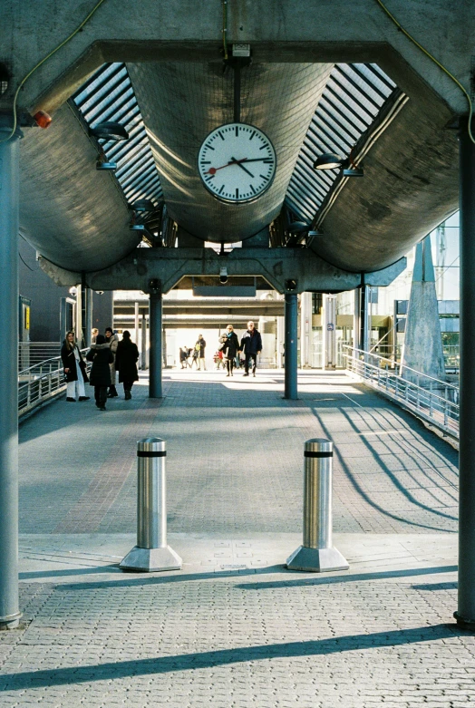 two clocks are displayed in the center of an outdoor covered area