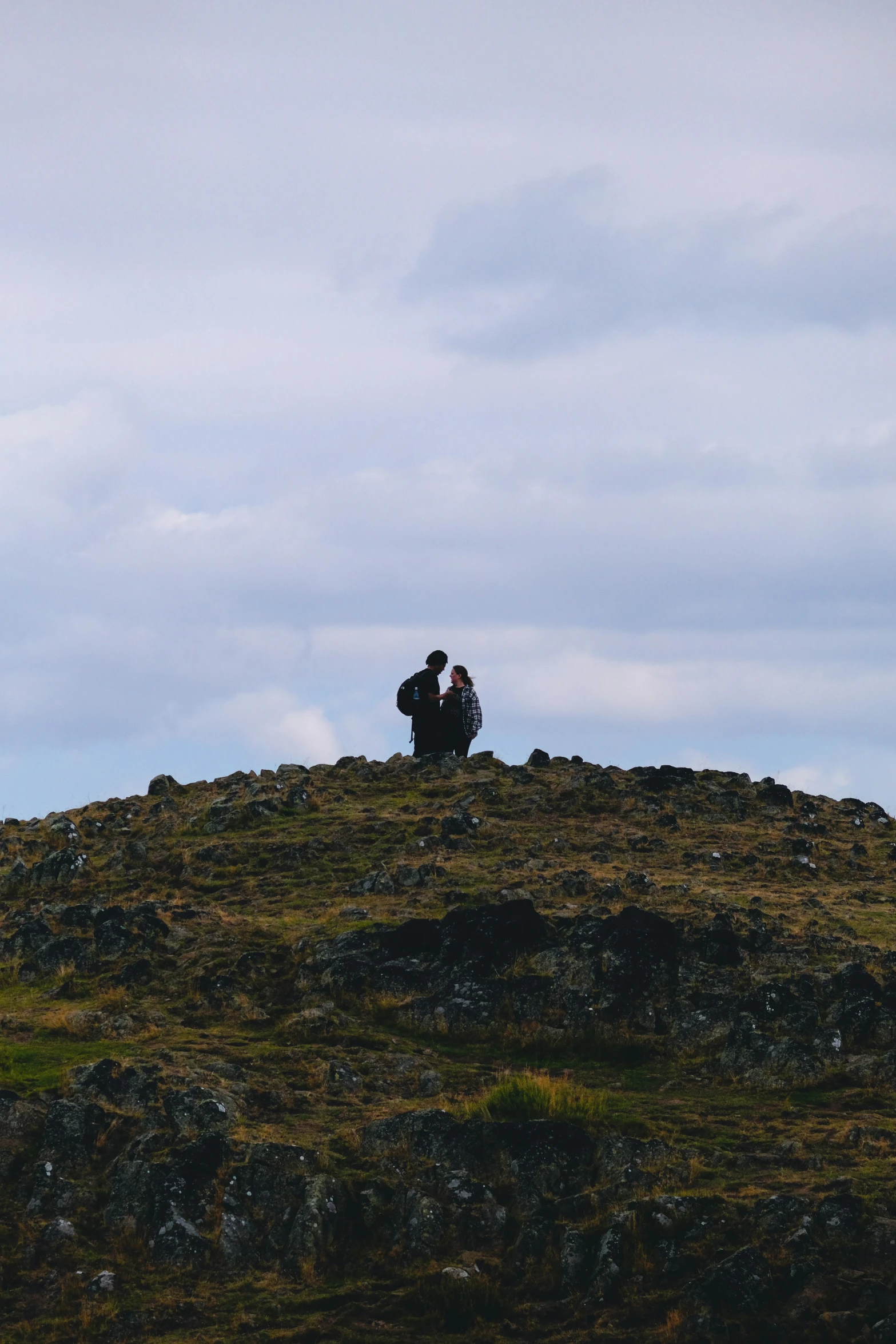 a person sitting on top of a rock hill