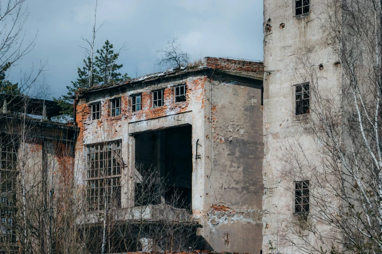 an old run down building with broken windows and some trees