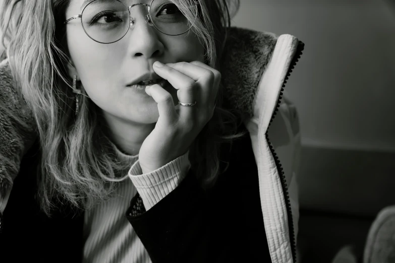 a woman is holding her nose up and wearing glasses