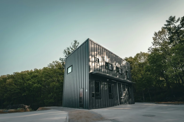 a tall black building surrounded by lots of trees