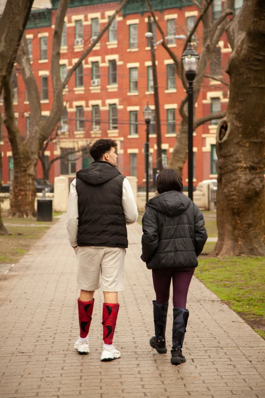 two people walking down a path in the park together