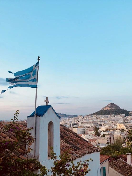 a small white church with a flag flying in the foreground