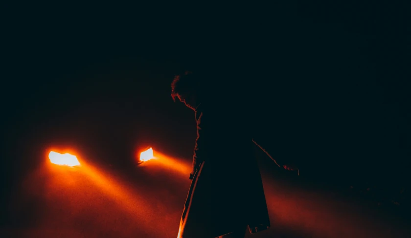 two people standing under a light in the dark