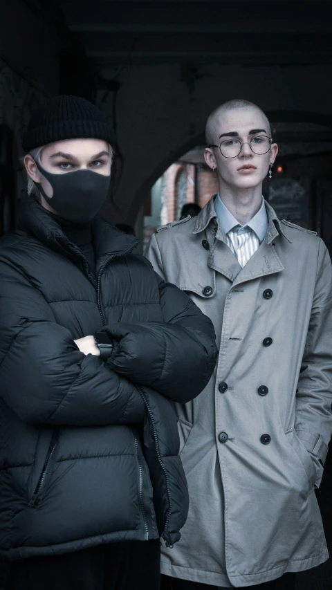 two people in coats standing outside a building