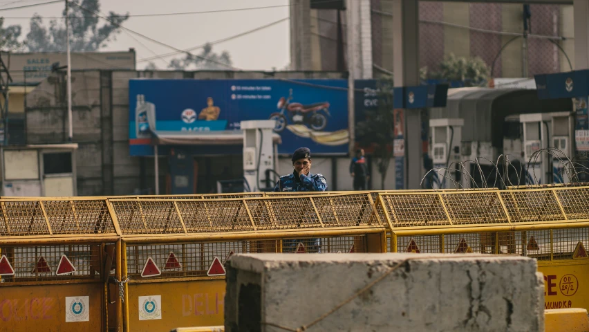 a security guard walks in front of a line of metal cages