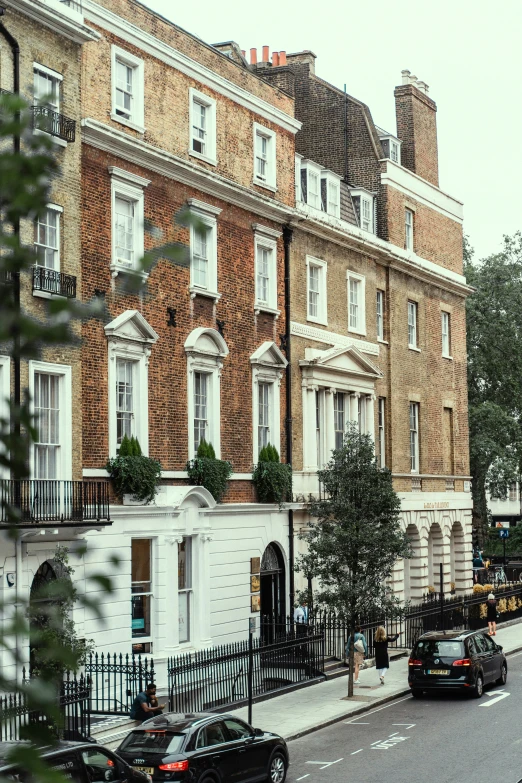 the view of several buildings in an area with cars parked on the street