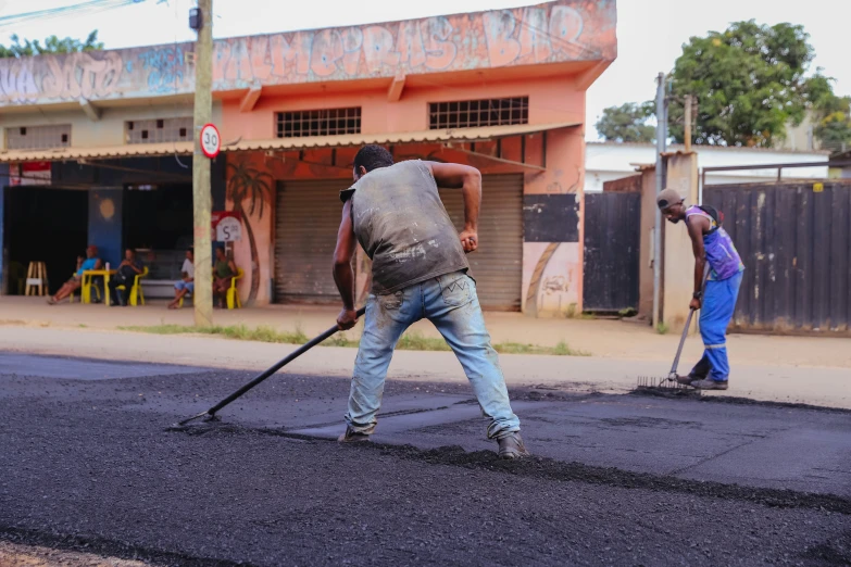 a man with a large stick walking across the road