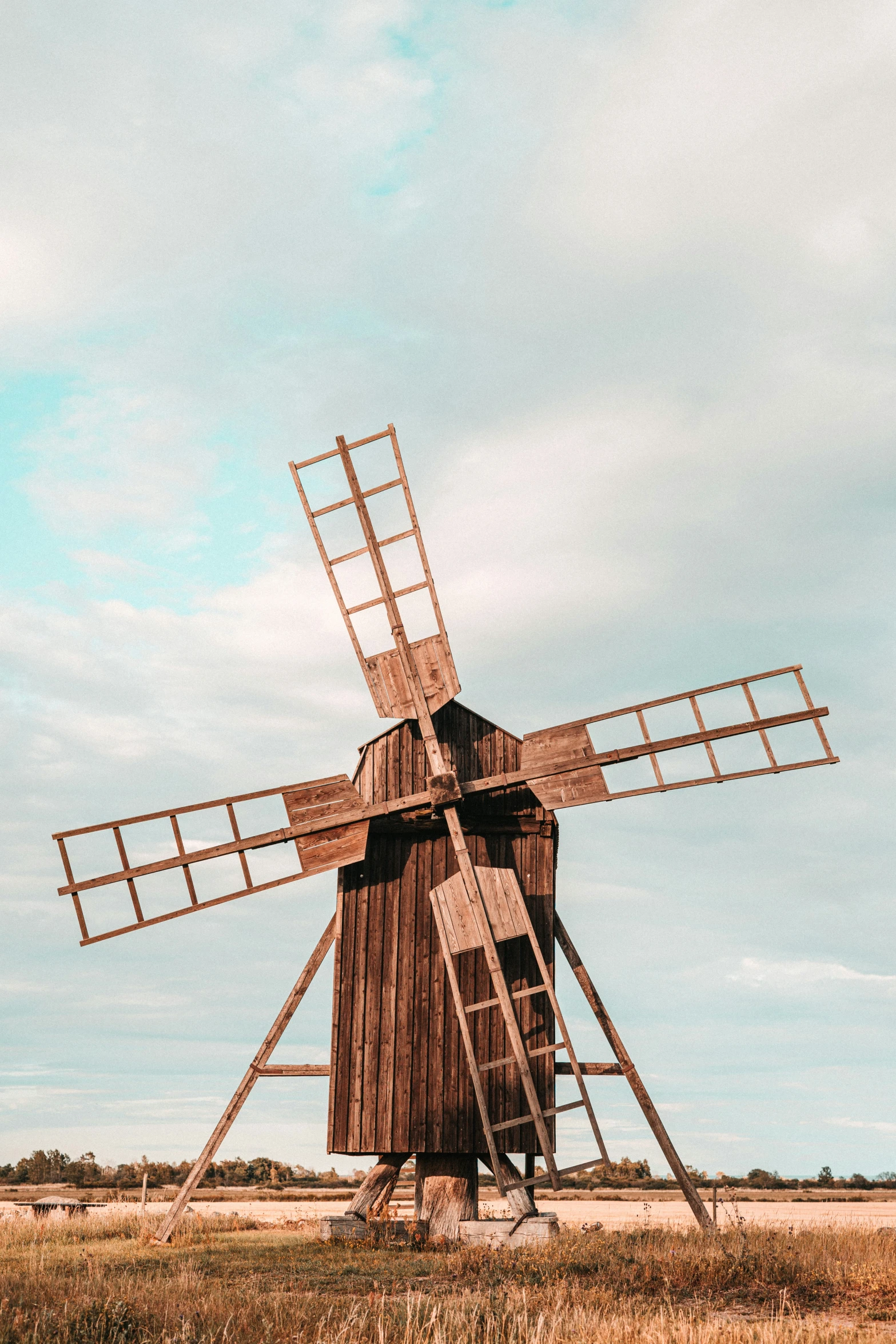 an old windmill is in a dry field