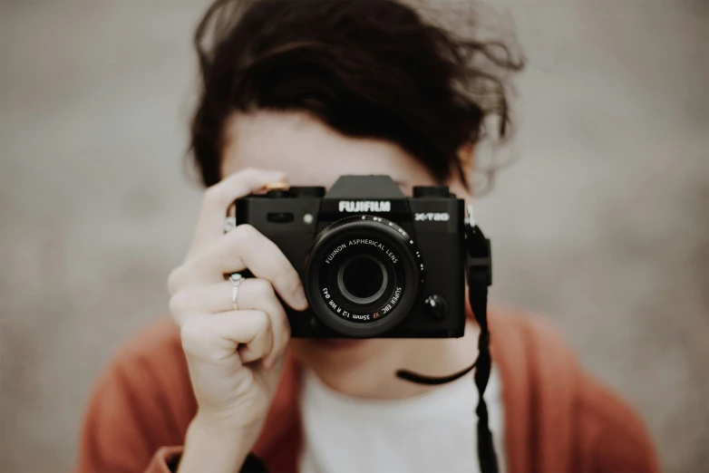 a woman is holding a camera up to the camera