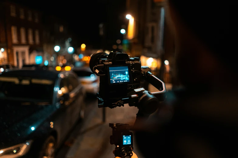 a camera operator recording a car at night